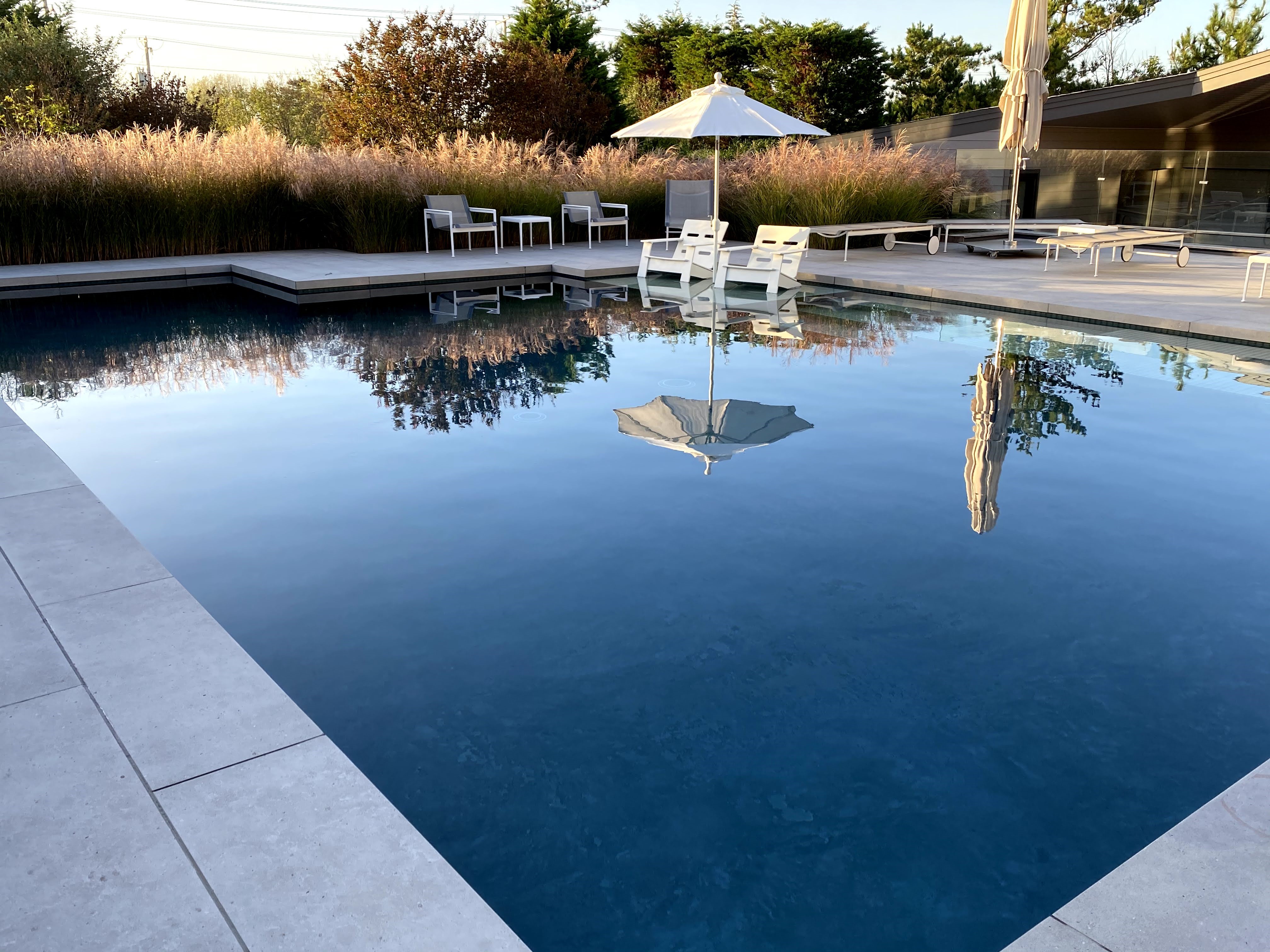 Linear marble-deck pool reflecting sky, Loveladies, NJ