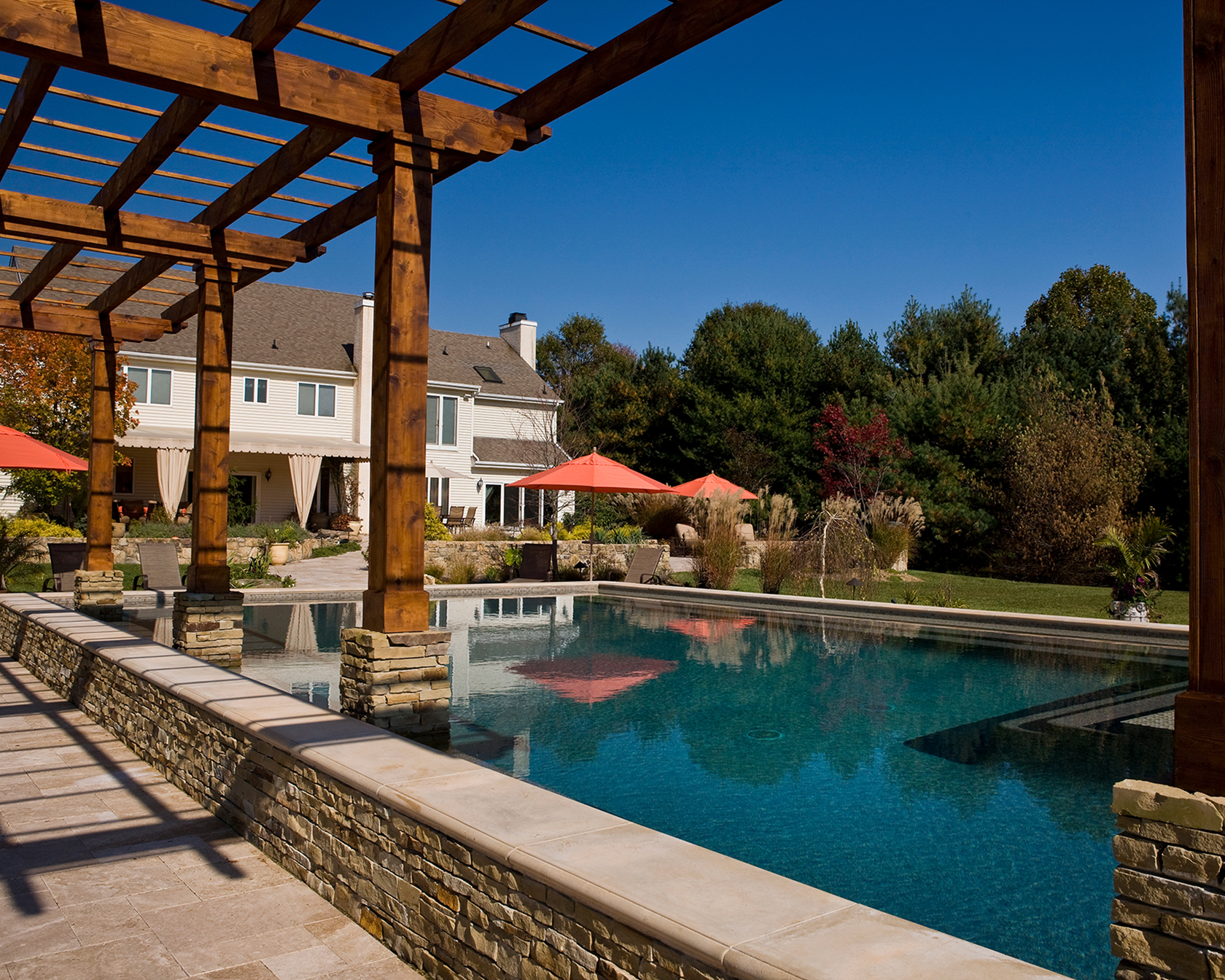 Sun shelf with in-water seating creating soft reflections across the pool surface.