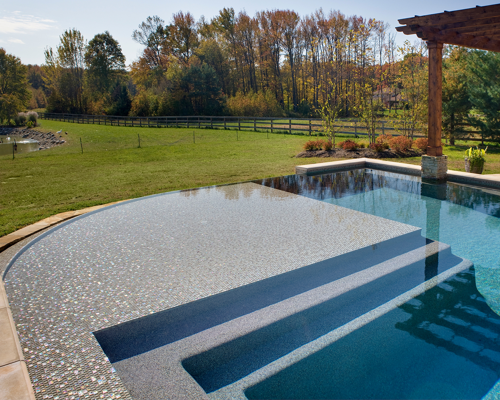 Vanishing-edge detail and curved steps capturing sky reflections in the water