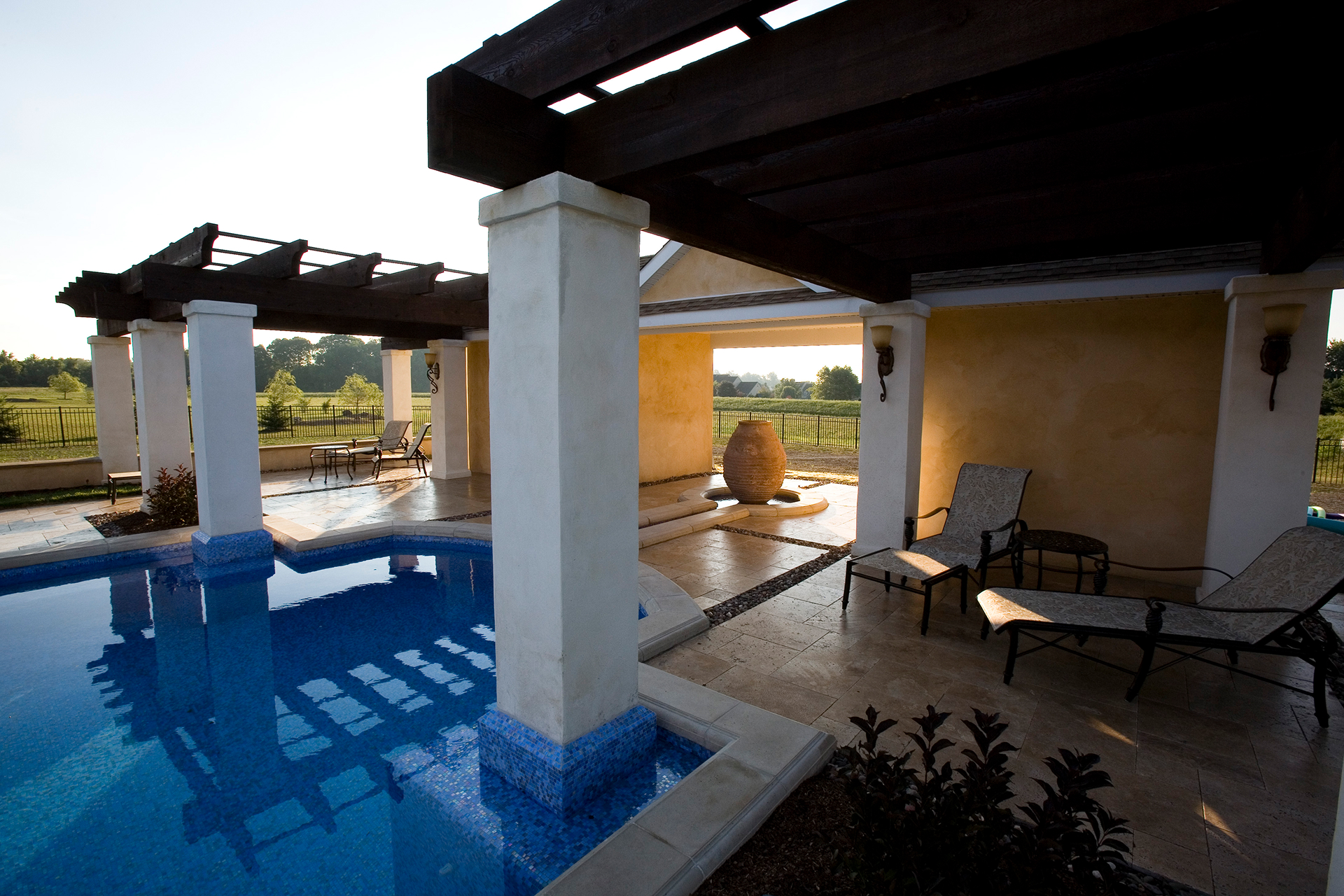 Custom glass mosaic sun set into the thermal ledge of a Mediterranean luxury pool in Newtown, Pennsylvania.