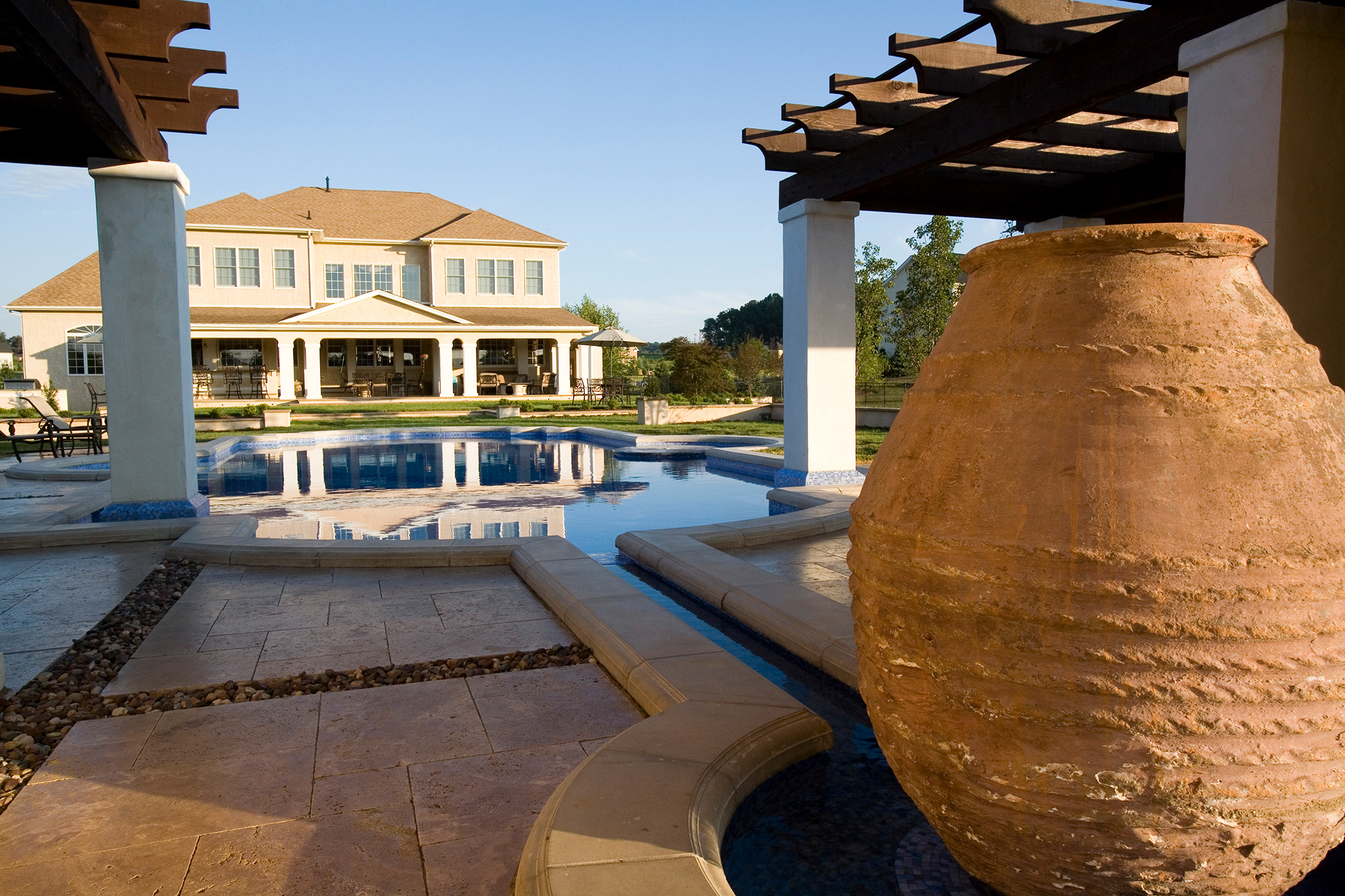 Formal lawn axis with stepping pads leading to the Mediterranea luxury pool in Newtown, Pennsylvania.