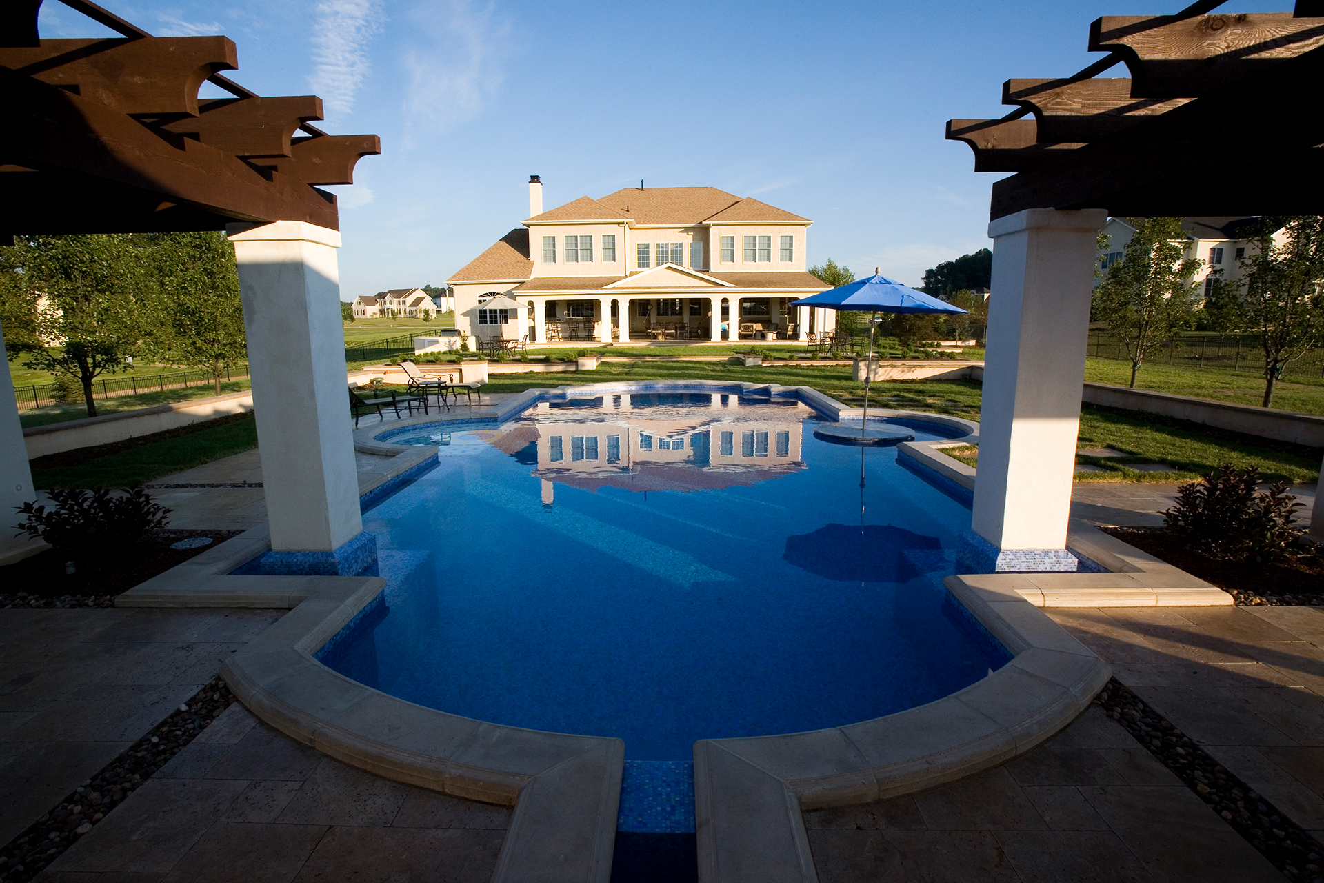 Central-axis view through the pavilion to the olive urn anchoring the Mediterranea luxury pool in Newtown, PA.
