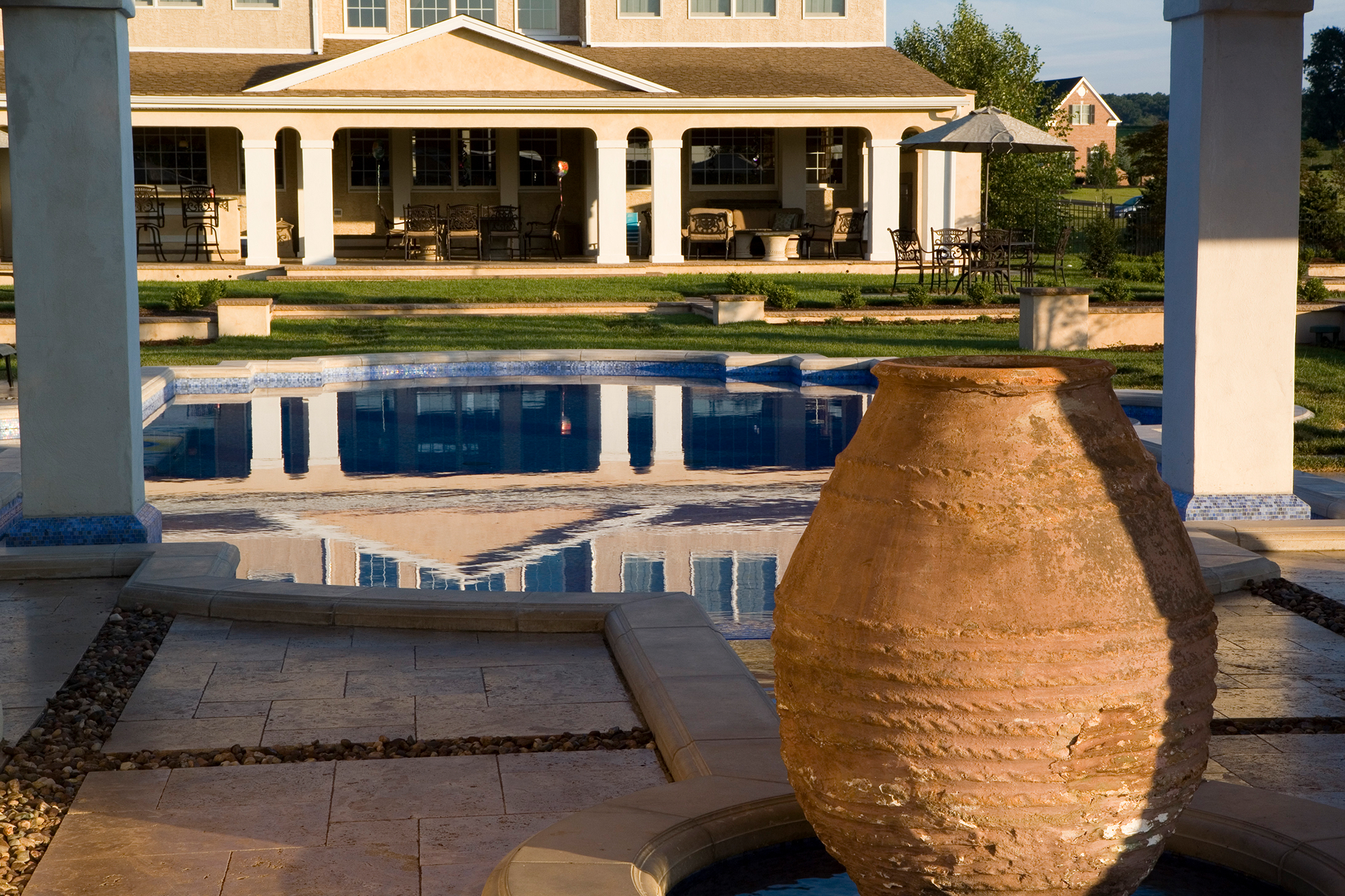 Hero view of Mediterranea luxury pool design in Newtown, PA with balanced symmetry and classic Mediterranean detailing