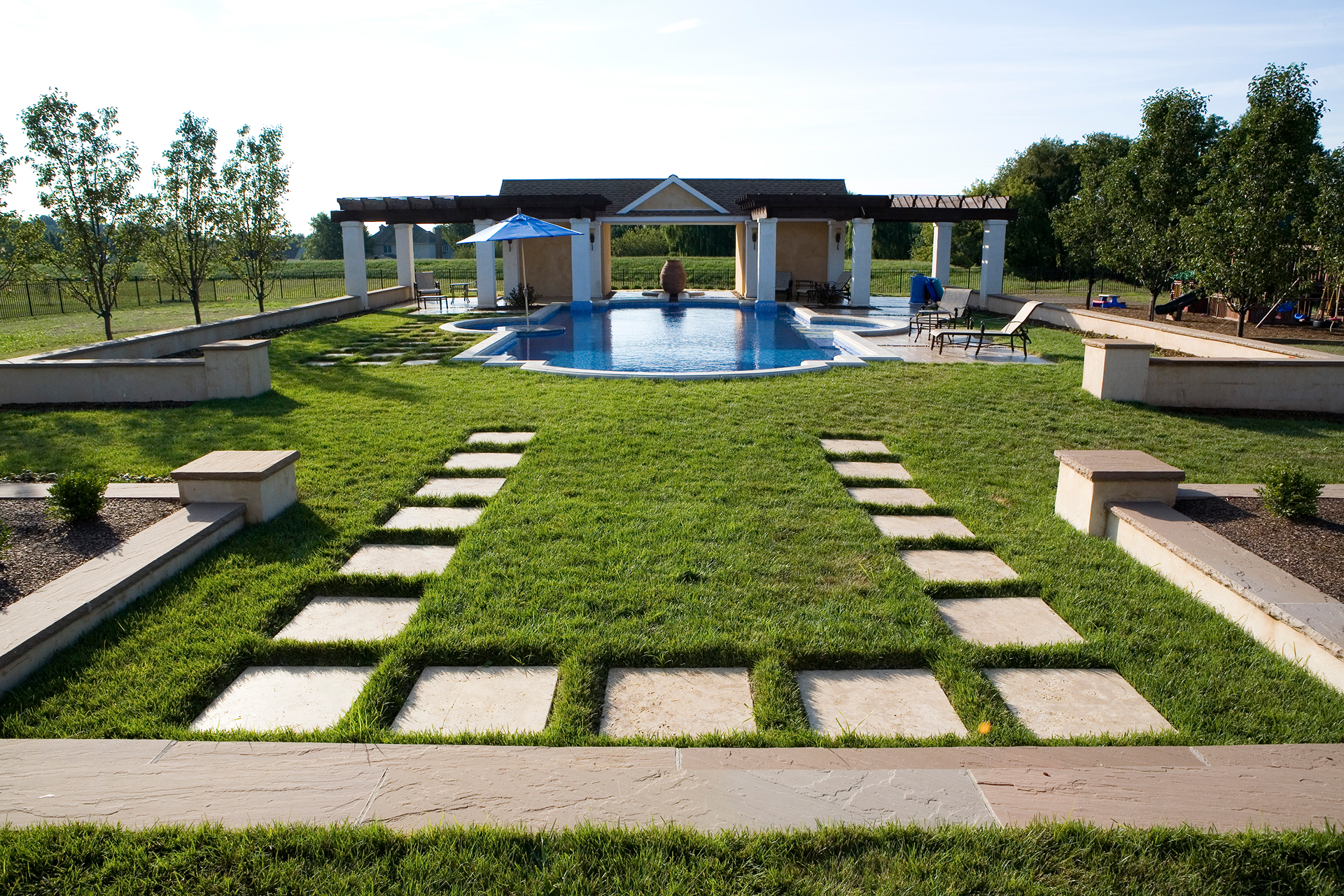 Pergola columns and urn detail beside a Mediterranean-inspired luxury pool in Newtown, Pennsylvania