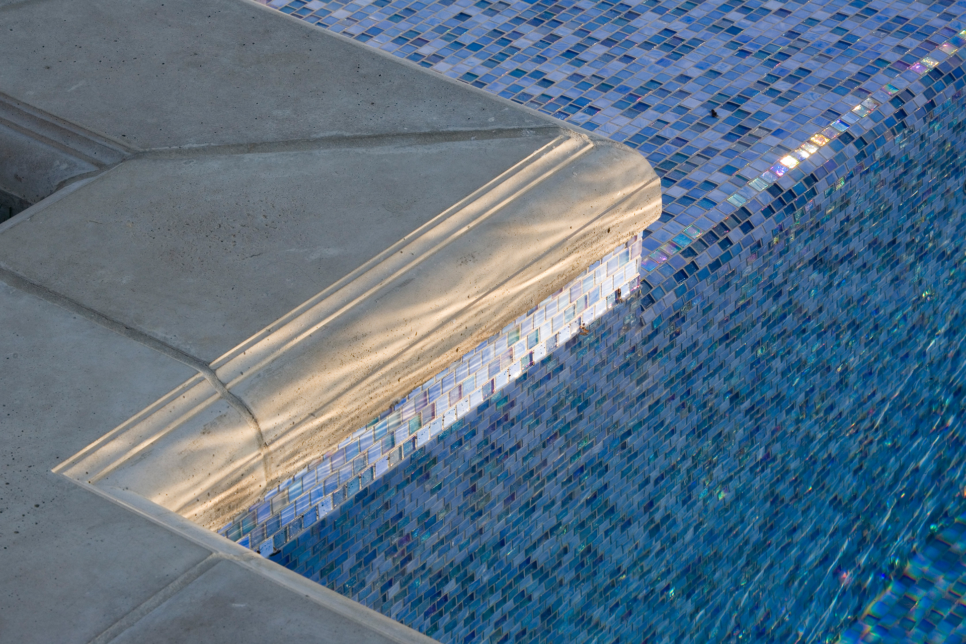 Symmetrical facade and pergolas framing a luxury Mediterranean pool at a Newtown, PA residence