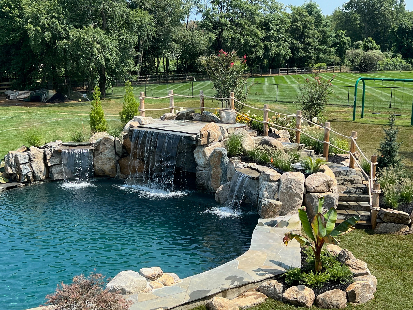 Natural-stone grotto pool with cascading waterfall and boulder edging in Colts Neck, NJ.