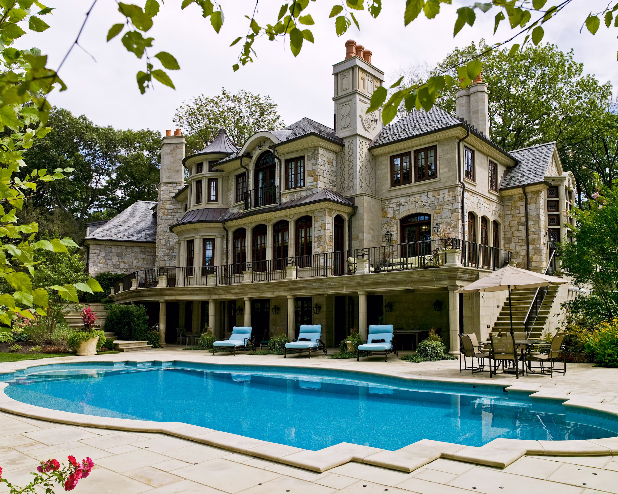 Stately manor façade overlooking a sculpted luxury pool with expansive deck and seating, Essex Fells, New Jersey