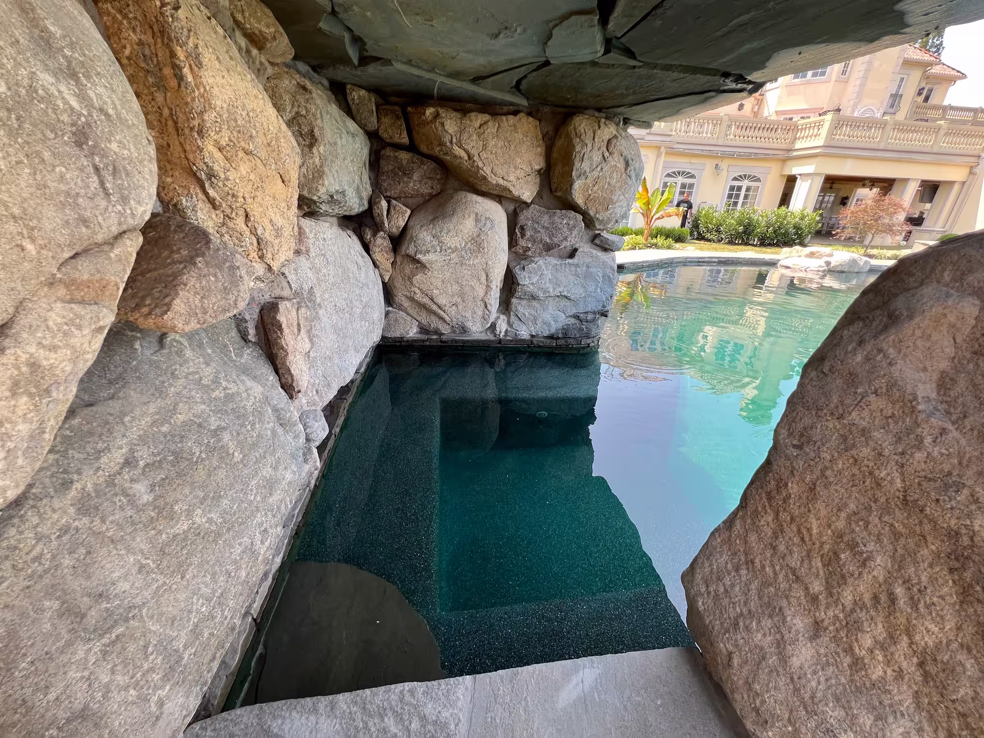 Landscape around grotto pool with rustic boulders and pavilion, Colts Neck, NJ.