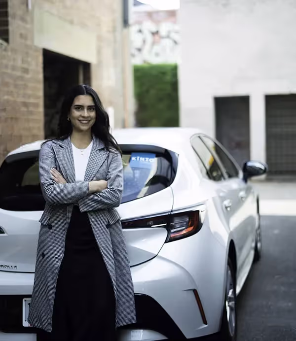 standing in front of a Toyota car from KINTO car hire