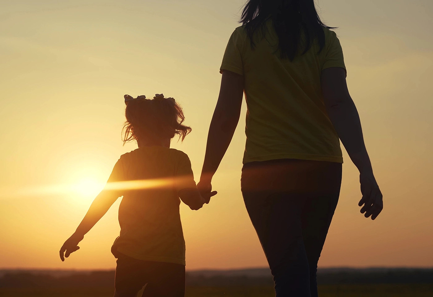 mother and daughter walk away into sunset after family law case in wyoming