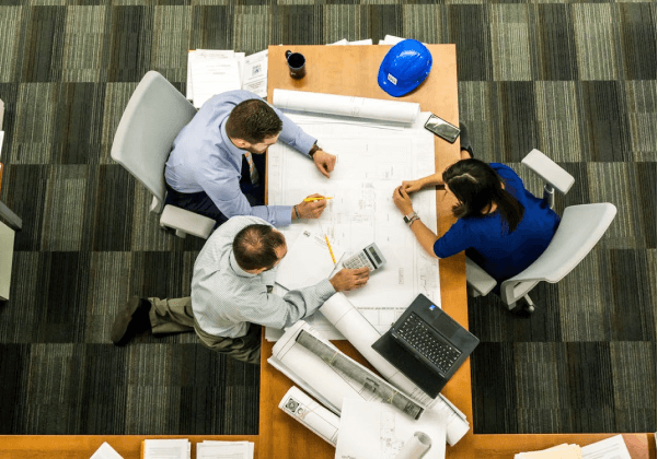 A group of people sitting around a table working on a project.
