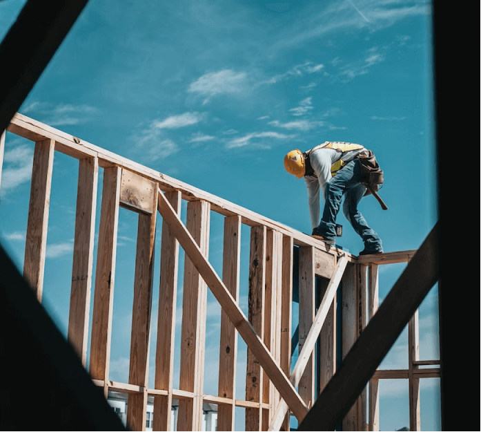 A construction worker working on a wooden structure.