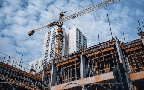 A crane is standing on top of a building under construction.