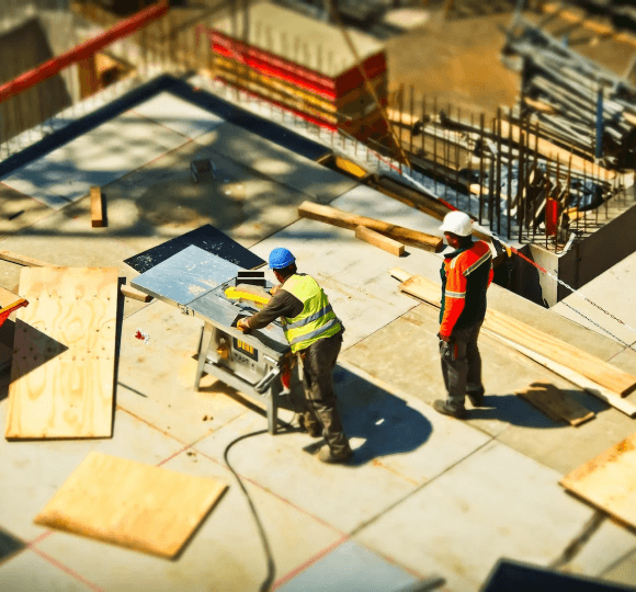 A couple of men standing on top of a roof.