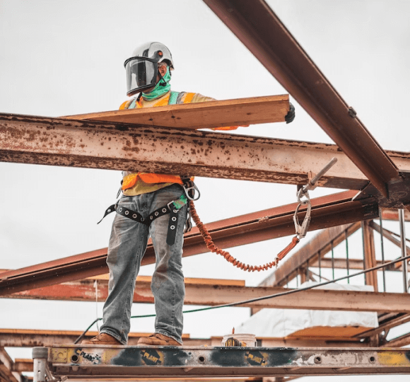 A man standing on top of a metal beam.