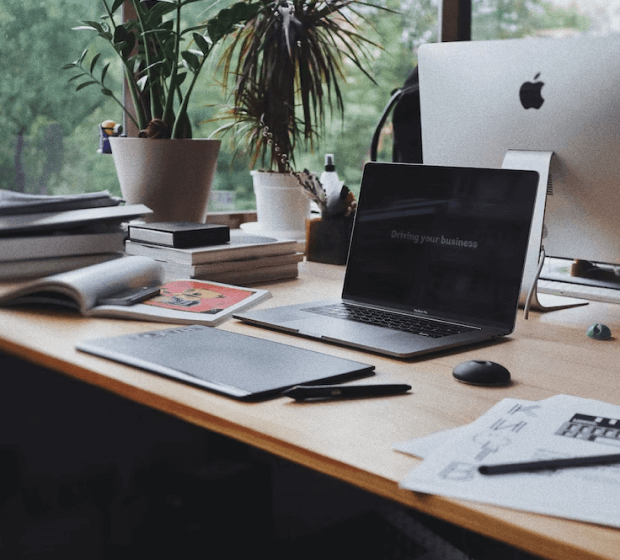 A wooden desk topped with a laptop computer.