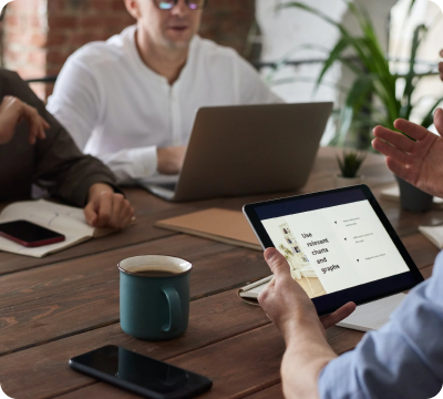 A group of people sitting around a wooden table.