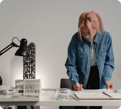 A woman writing on a piece of paper at a desk.