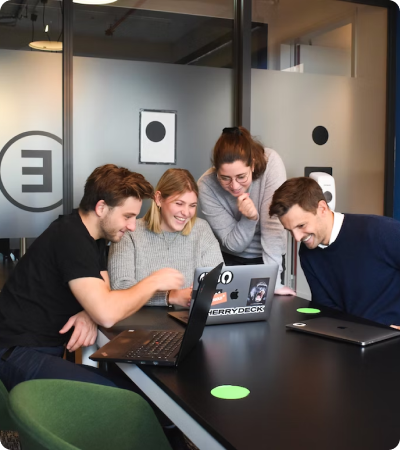 A group of people looking at a laptop.