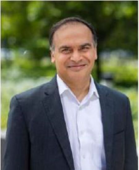 Smiling professional in dark suit and white shirt standing outdoors
