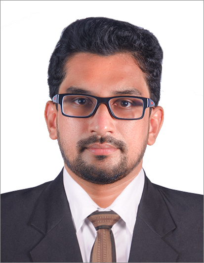 Professional headshot of a person in a suit and tie wearing glasses