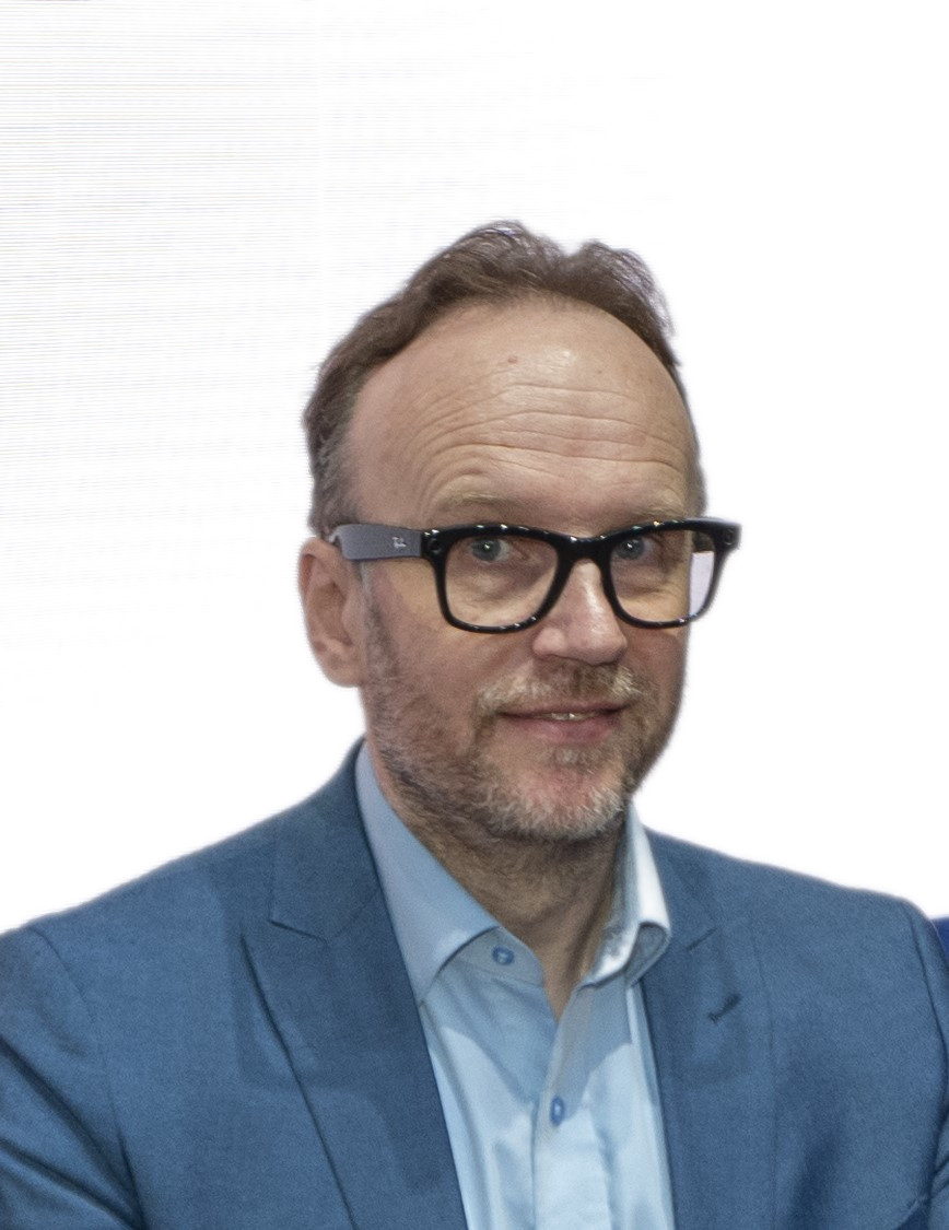 Middle-aged professional in blue blazer and glasses looking slightly to the side