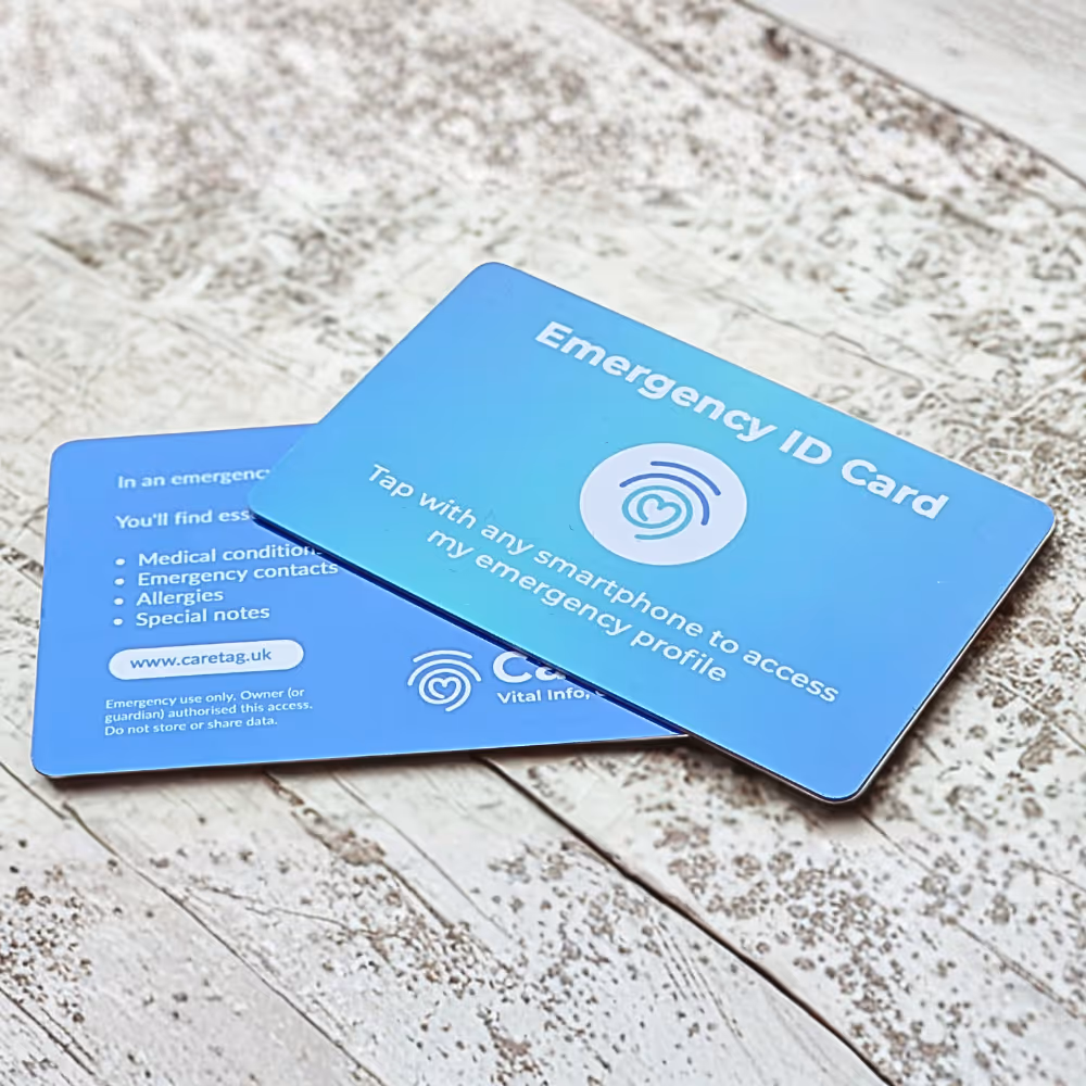 CareTag emergency ID cards on wooden surface showing NFC and QR code features.