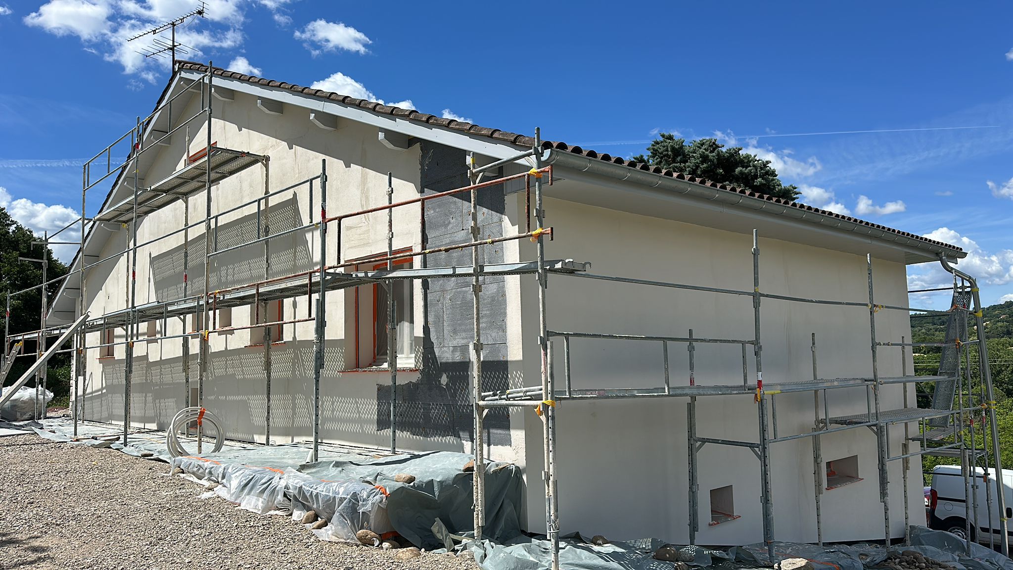 Chantier d'isolation thermique par l'extérieur à Barbières par DLS Facade avec isolant gris et échafaudage.