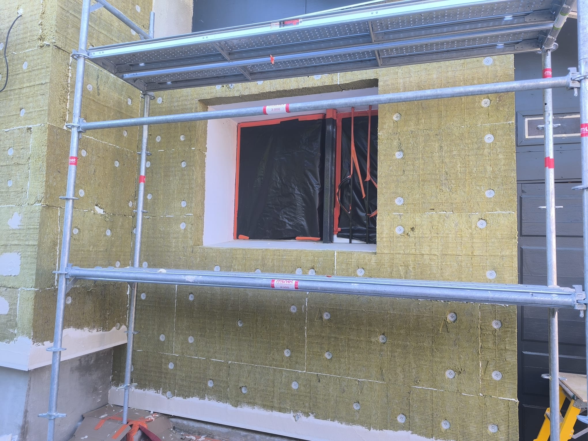 Pose de laine de roche sous échafaudage pour isolation thermique par l'extérieur à Beaumont-Monteux par DLS Facade.
