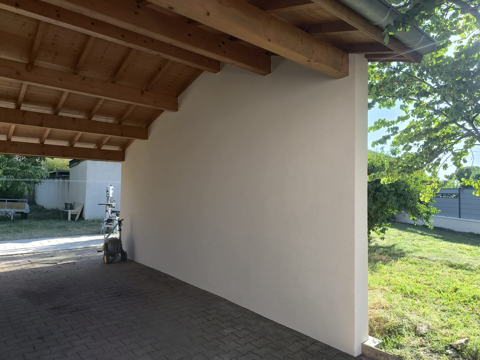Mur enduit beige sous auvent bois, isolation thermique par l'extérieur à Châteauneuf-sur-Isère par DLS Facade.