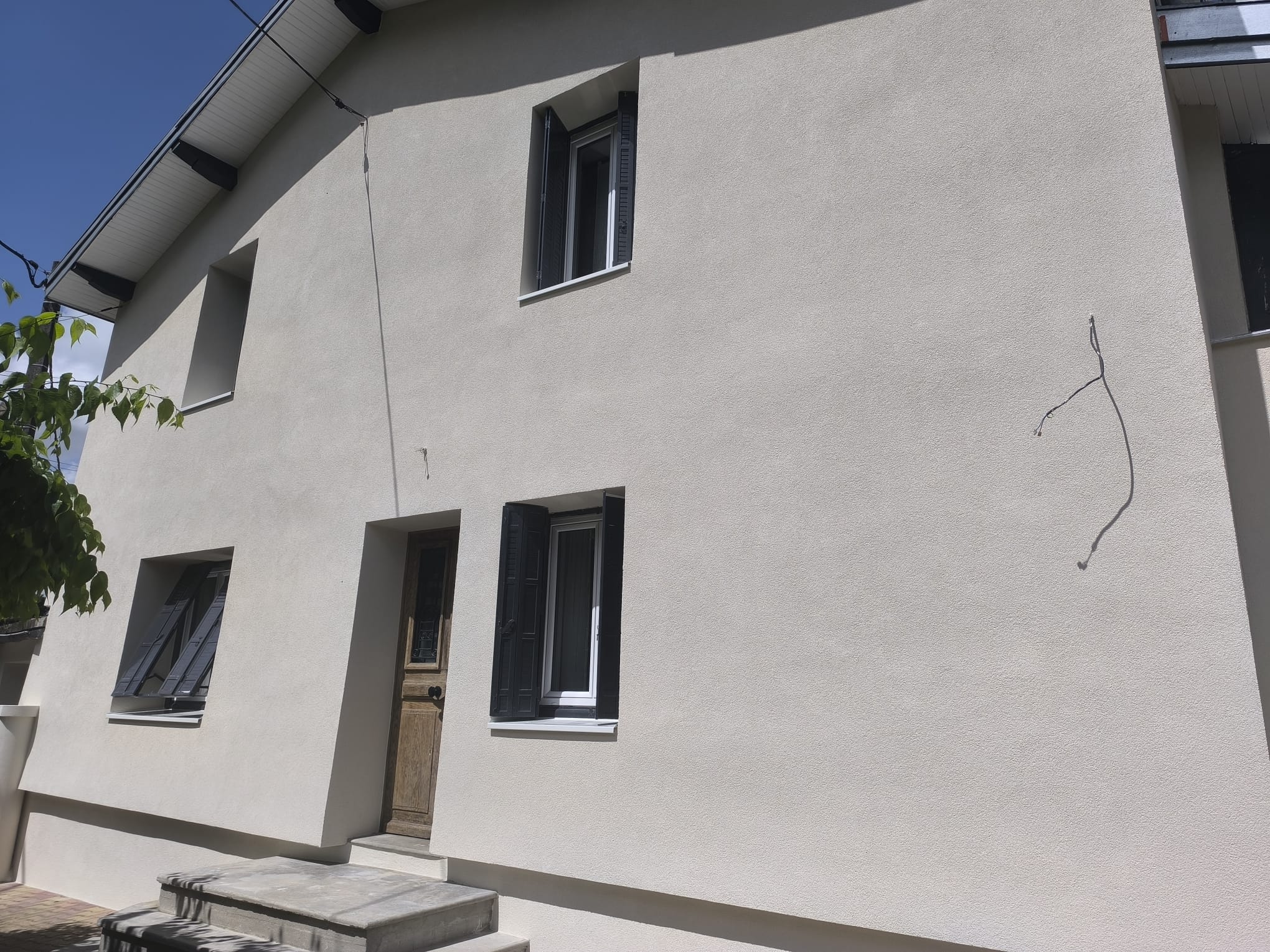 ade avec isolation thermique par l'extérieur à Montélier par DLS Facade, crépi beige et volets noirs. (104 chars) Wait, the prompt asks for