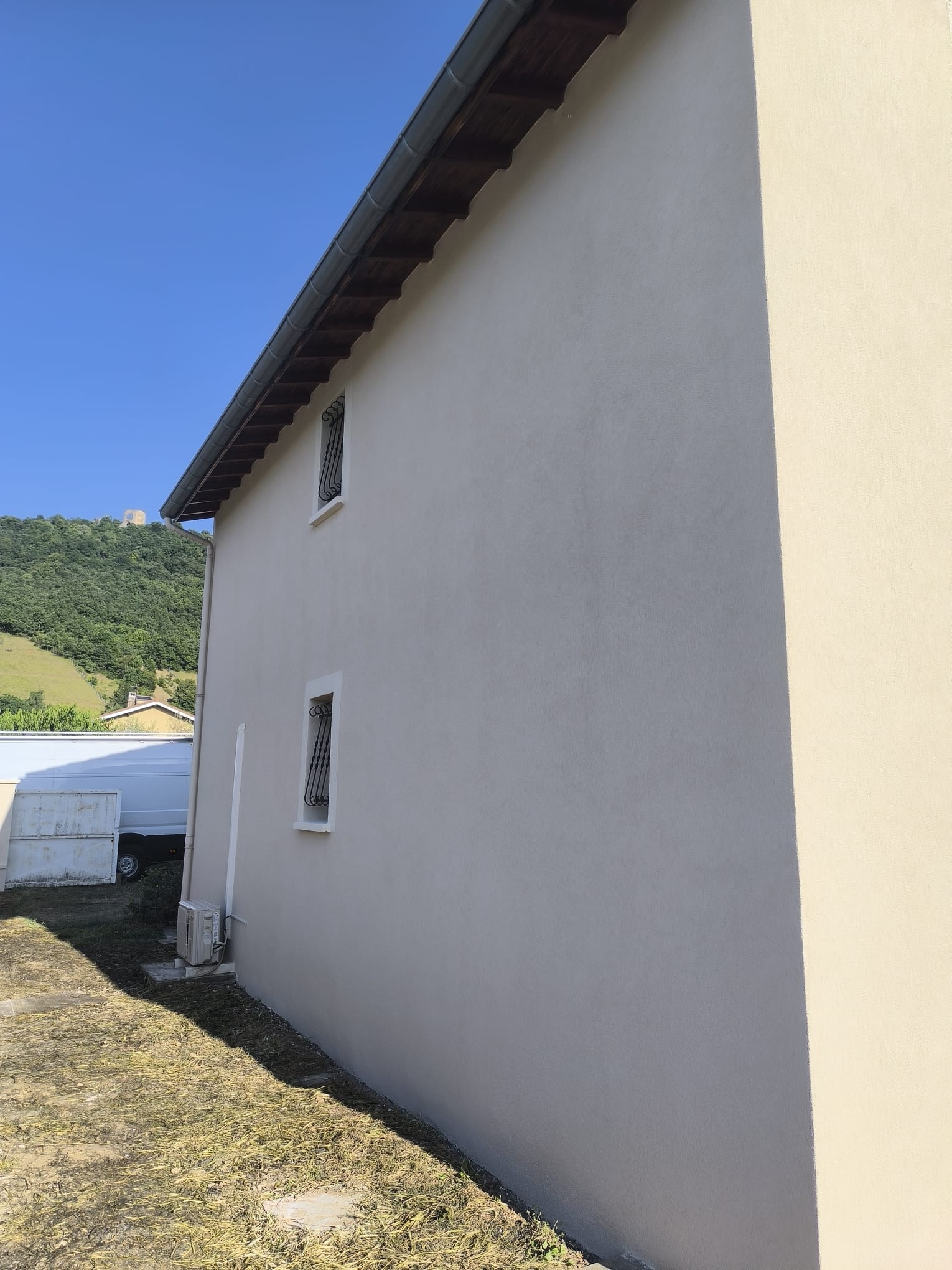 Façade beige et fenêtres à grilles, isolation thermique par l'extérieur à Saint-Barthélemy-de-Vals par DLS Facade.