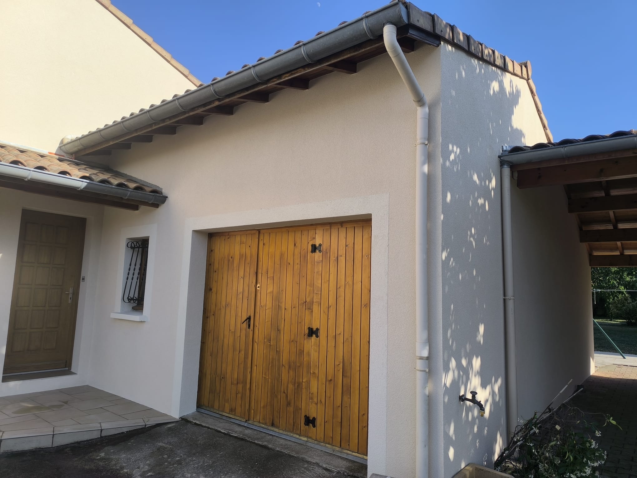 Façade beige et porte en bois : isolation thermique par l'extérieur à Saint-Barthélemy-de-Vals signée DLS Facade.
