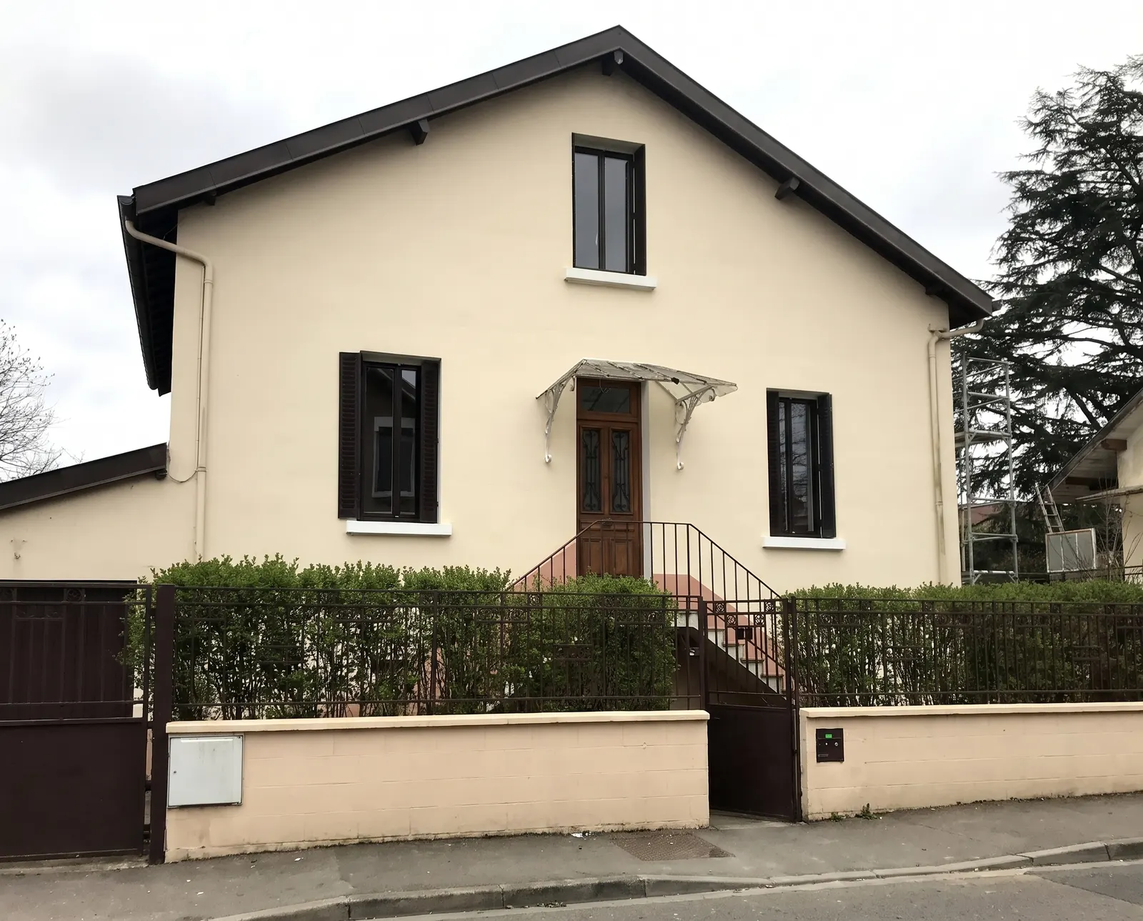 Maison beige aux volets sombres après un ravalement de façade à Allex par DLS Facade.