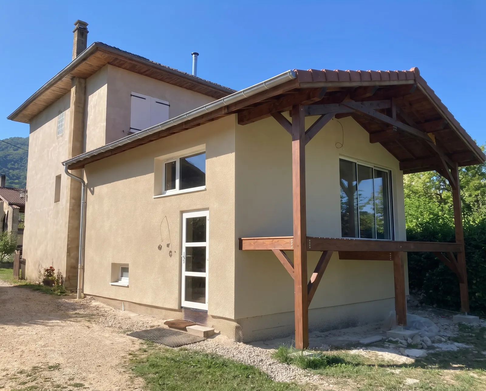 Ravalement de façade à Saillans par DLS Facade : maison au crépi beige et auvent en bois.