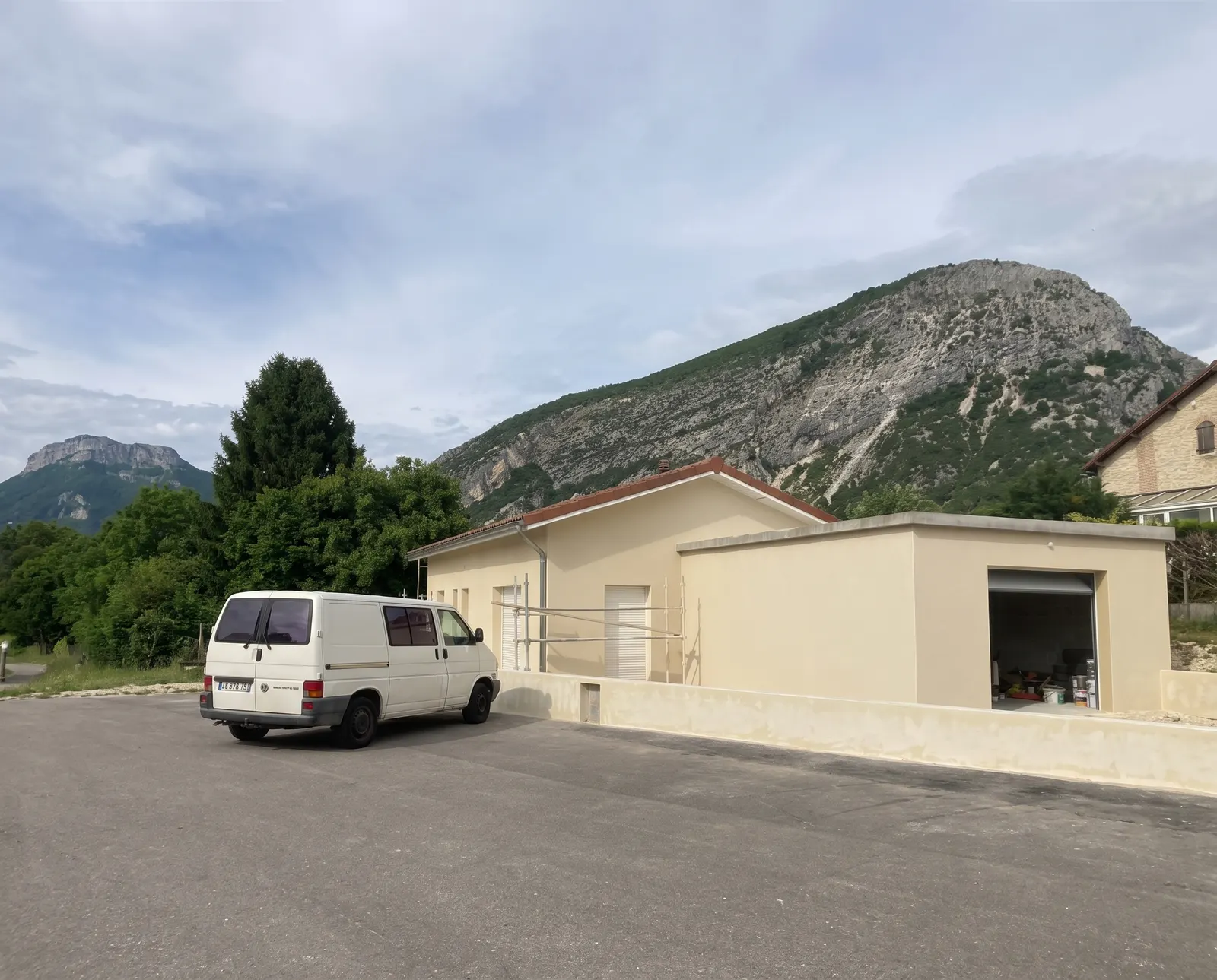 Maison beige sous les montagnes après un ravalement de façade à Valherbasse par DLS Facade.