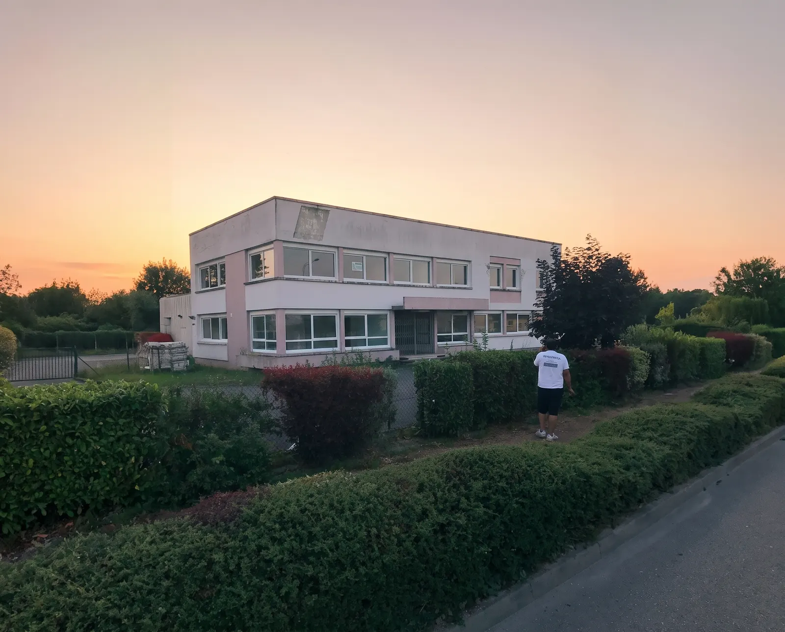 Bâtiment de bureaux avant ravalement de façade à Allex par DLS Facade au crépuscule.