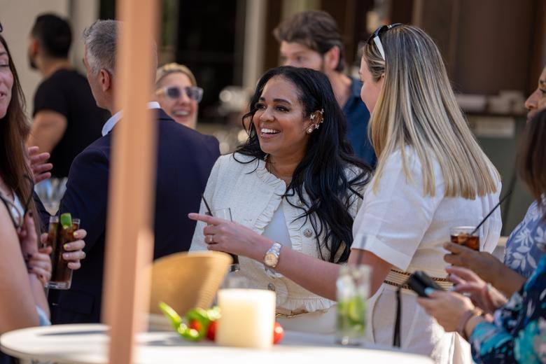 Guests laughing over drinks at an A305 event