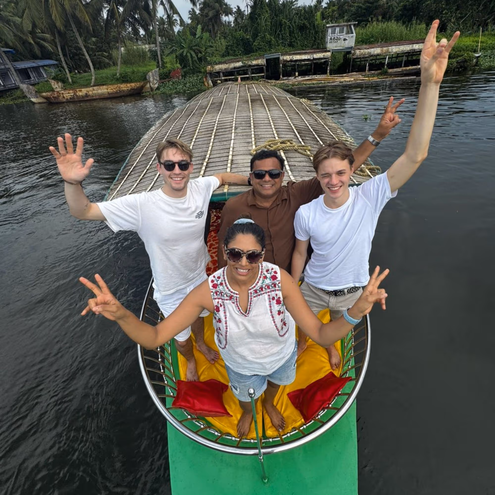 gap year to india on the Kerala backwaters with four adults in a boat waving