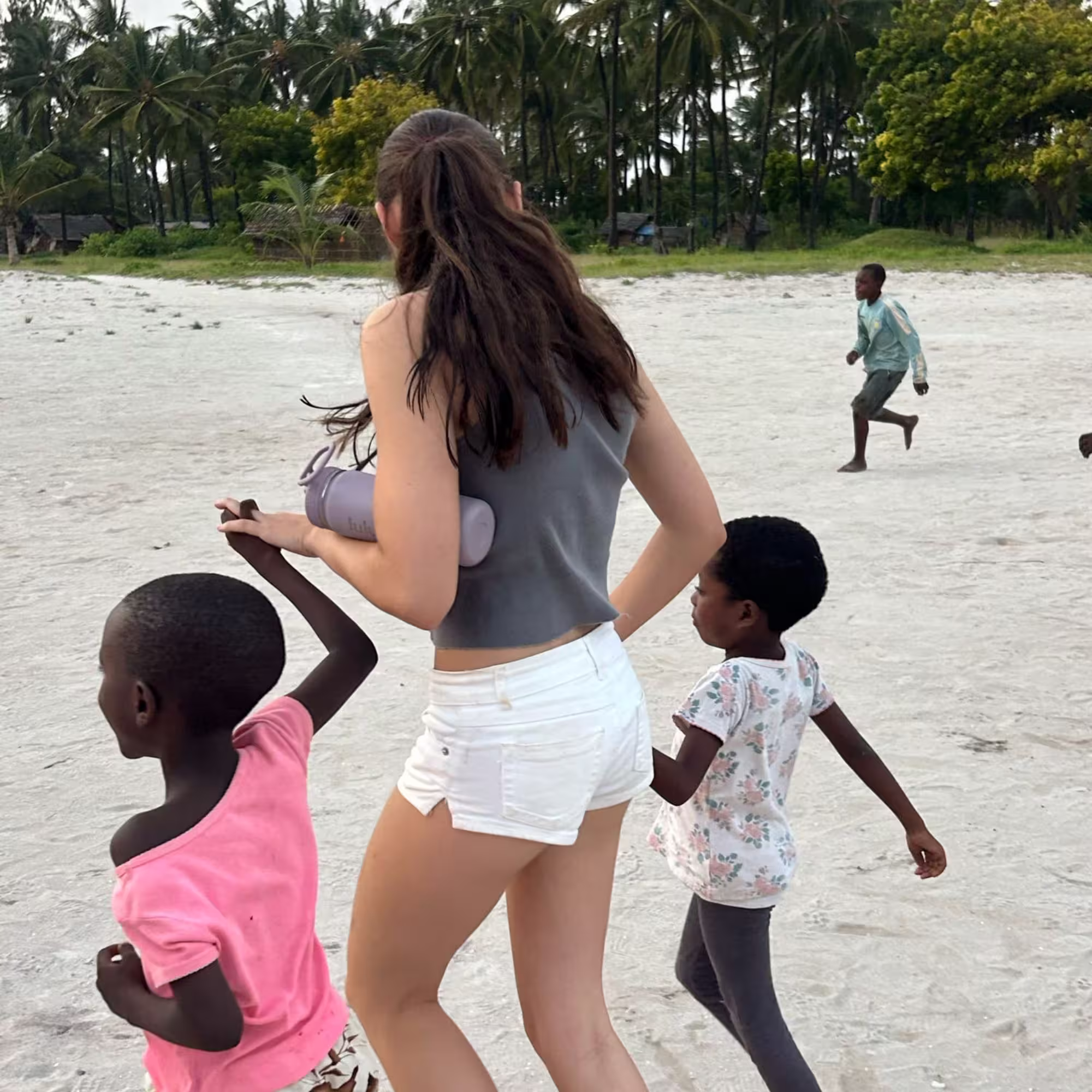 travel experiences for gap year and teens girl holding hands with kids from the community in kenya