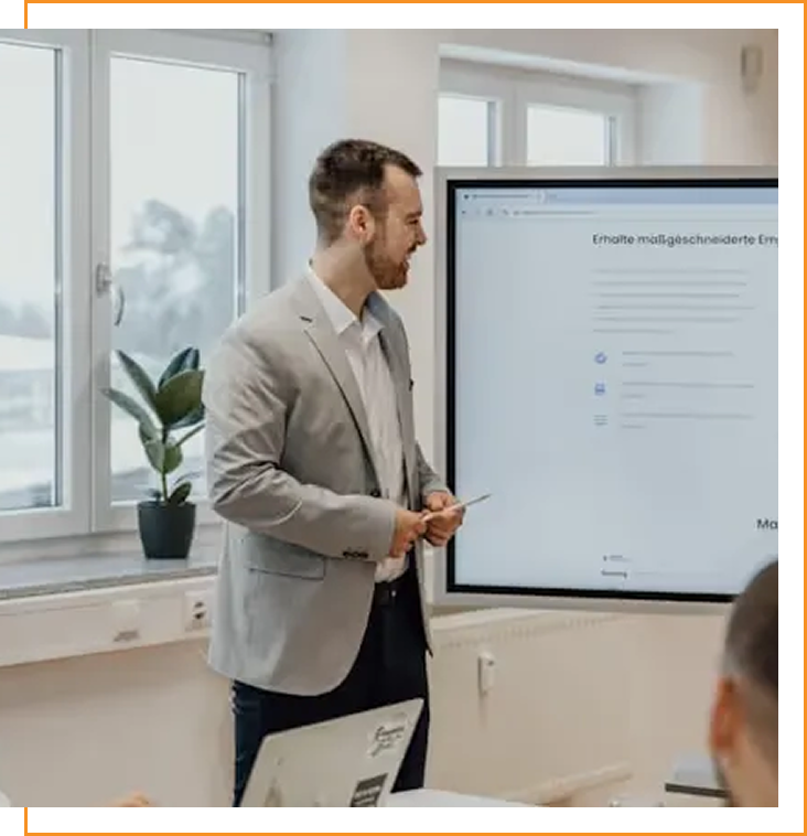 Confident woman in a blue shirt holding a blue folder standing in a modern office with glass walls.