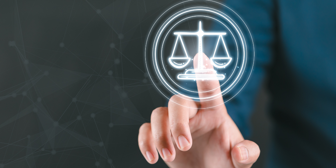 Close up of a person pushing a lit up button shaped like the scales of justice. 