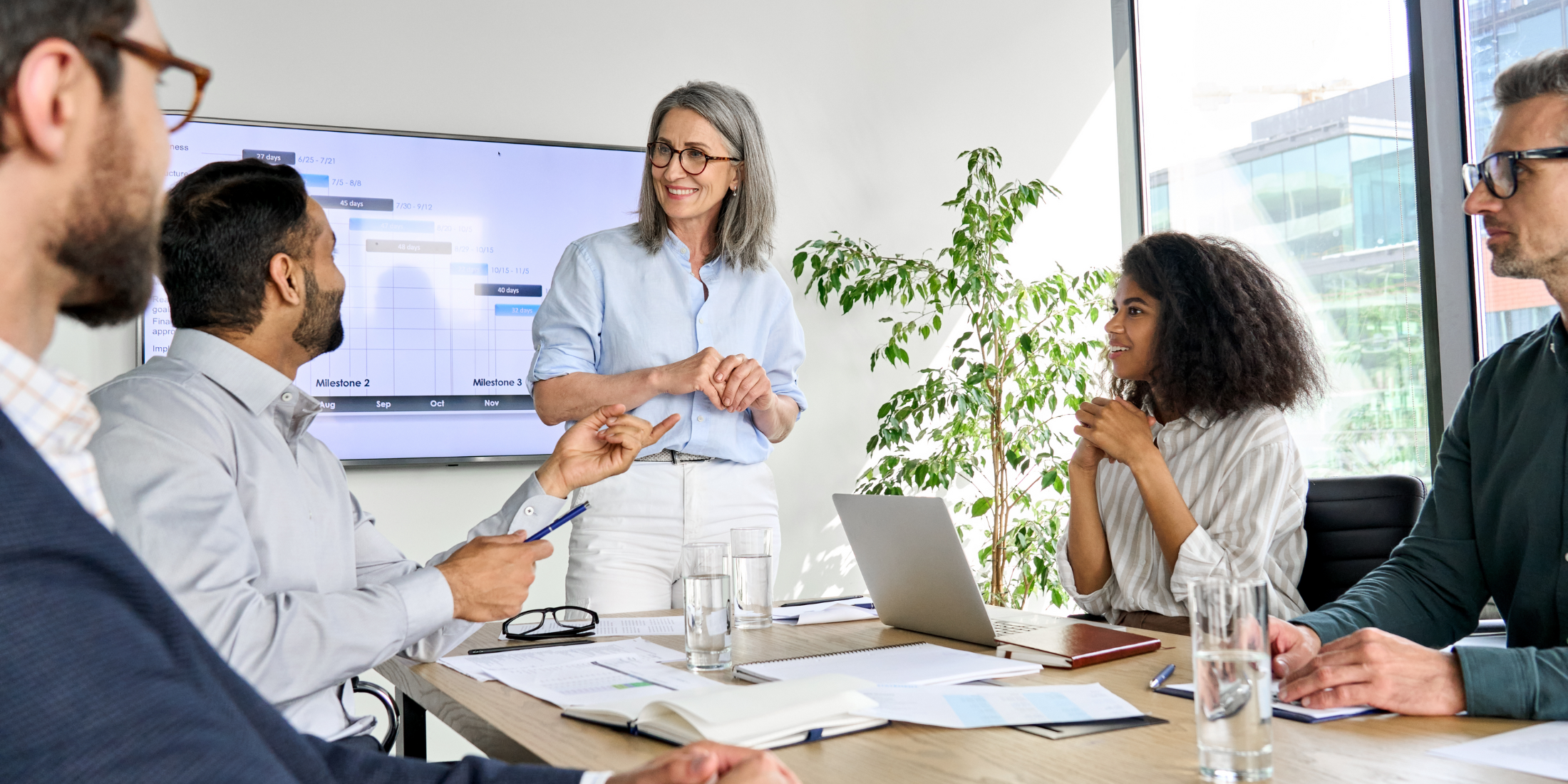 A CEO speaks with colleagues in a boardroom.