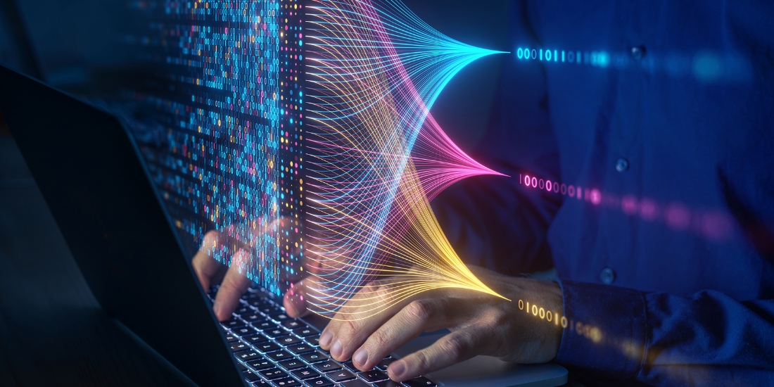 Person typing on laptop alongside data fabric imagery