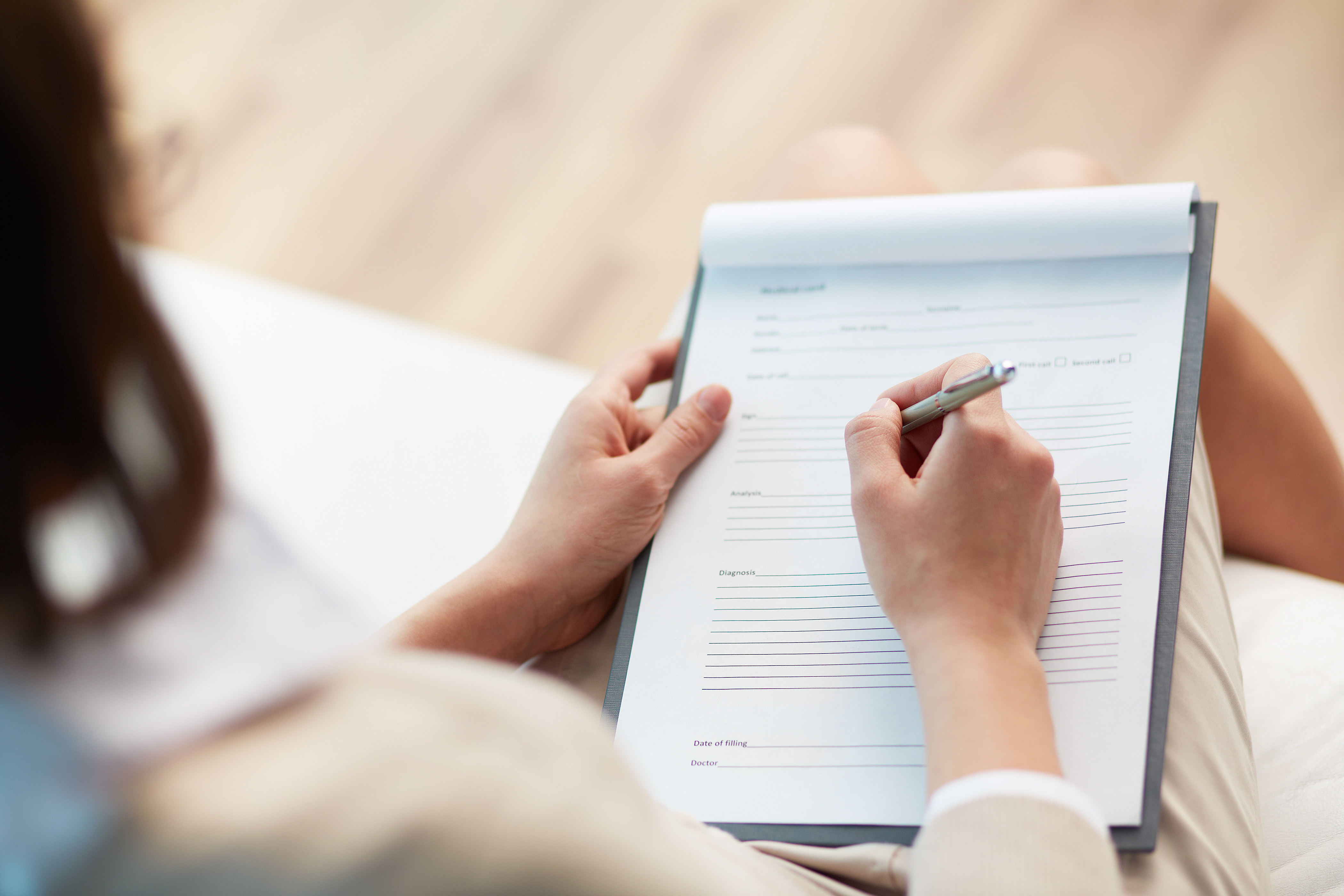 Woman writing on white notepad