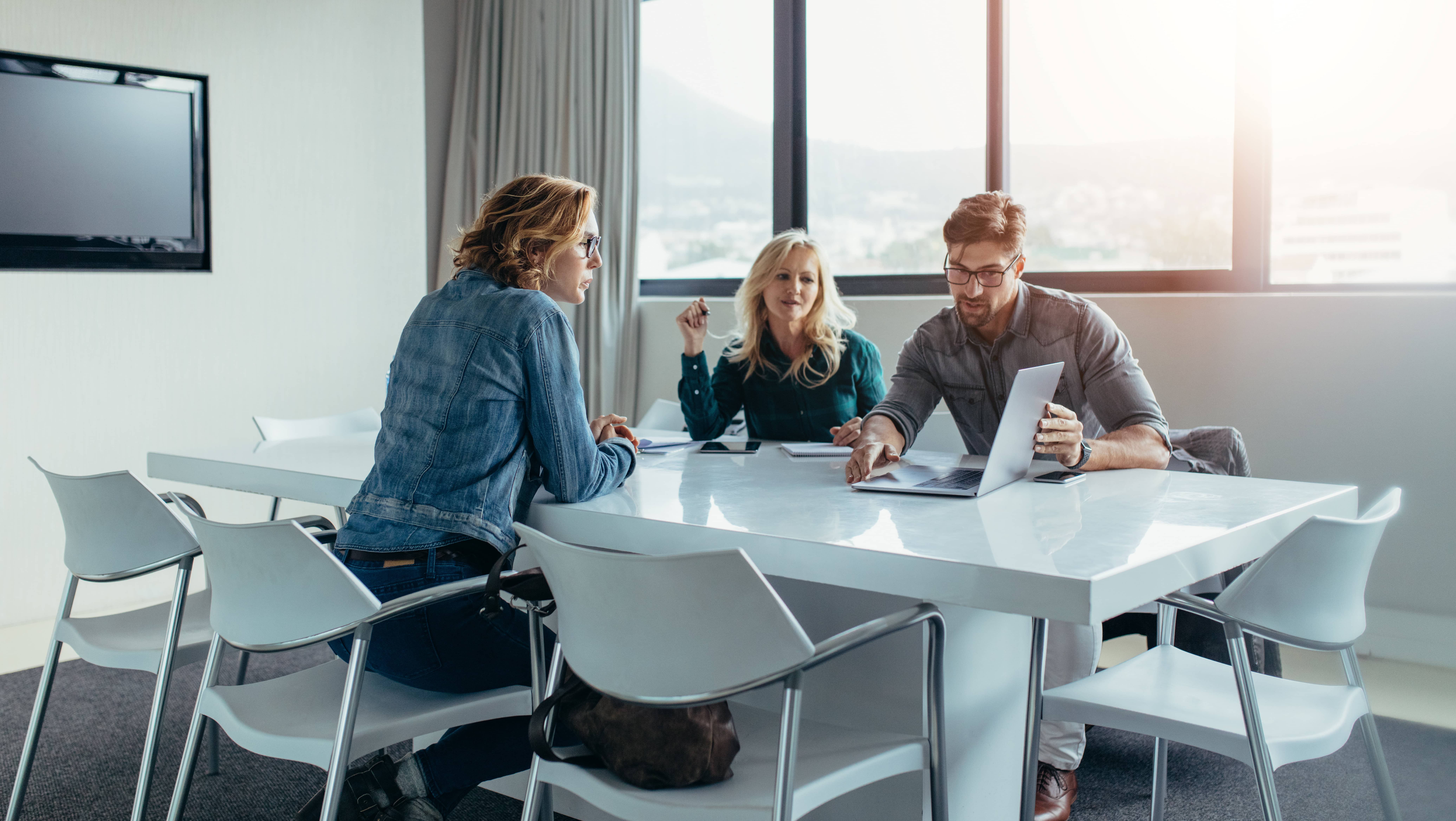 Two women, one man at conference room table