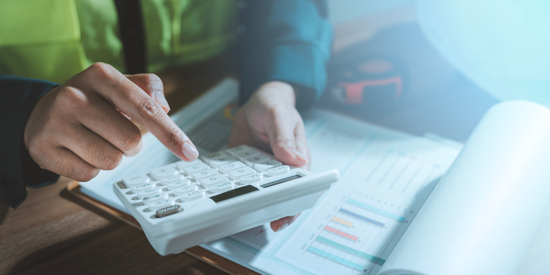 A close up of a person using a calculator and looking at graphs.