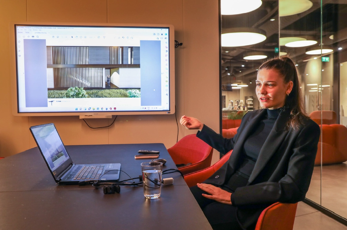 Arkitekt Diana Tofan presenterer et boligprosjekt på storskjerm i et møte
