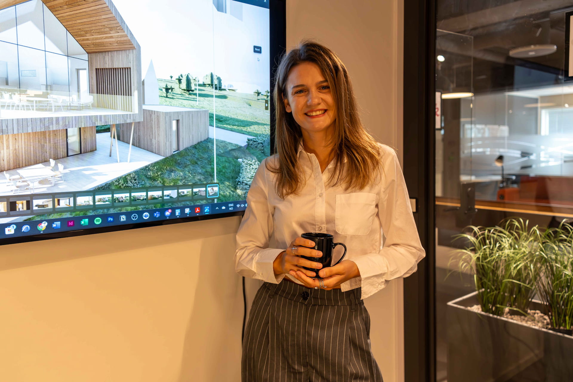 Arkitekt Diana Tofan ved en skjerm som viser et boligprosjekt, på arkitektkontoret