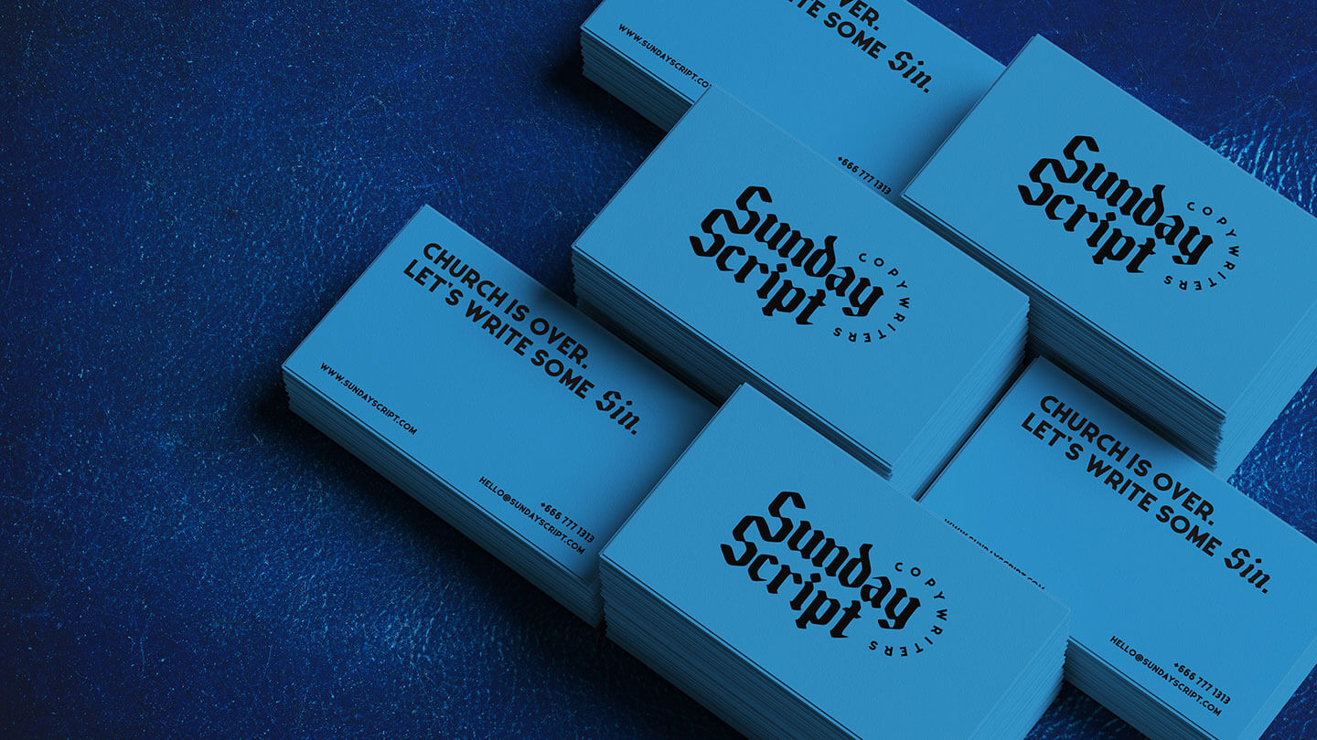 Multiple bright blue business cards from Sunday Script on a blue leather background